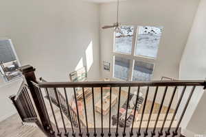 Stairs featuring carpet, a towering ceiling, and ceiling fan