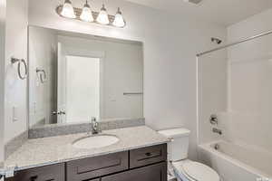 Full bathroom with vanity, shower / bath combination, and toilet