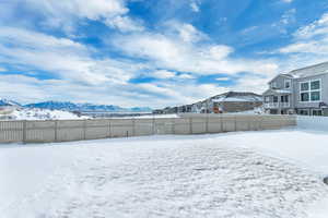 Yard layered in snow with a mountain view