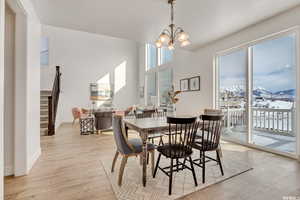 Dining area with a mountain view, an inviting chandelier, and light hardwood / wood-style flooring