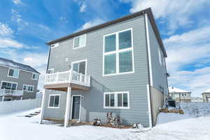 Snow covered house with a balcony and cooling unit