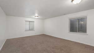 Unfurnished room with carpet floors and a textured ceiling