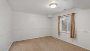 Carpeted empty room with a textured ceiling