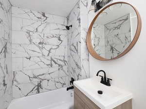 Bathroom featuring vanity and tiled shower / bath