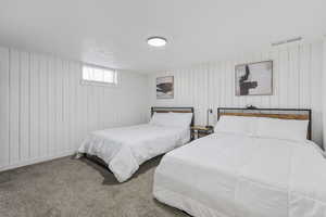 Carpeted bedroom with wood walls