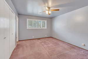 Unfurnished bedroom featuring light carpet and ceiling fan