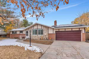 Single story home with a garage and solar panels