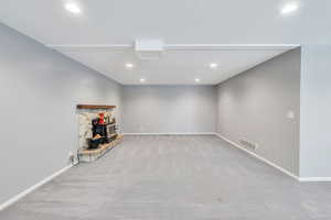 Interior space with light colored carpet and a wood stove