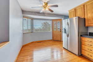 Kitchen featuring ceiling fan, stainless steel fridge with ice dispenser, and light hardwood / wood-style flooring