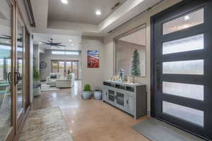 Foyer entrance featuring french doors, a raised ceiling, and ceiling fan