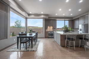 Kitchen featuring a healthy amount of sunlight, a kitchen island, backsplash, and appliances with stainless steel finishes