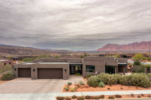 Pueblo-style house featuring a mountain view and a garage