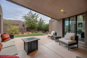 View of patio featuring an outdoor living space with a fire pit