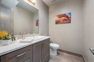 Bathroom featuring tile patterned flooring, vanity, and toilet