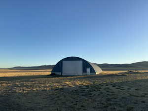 View of outbuilding featuring a mountain view, a rural view, and a garage