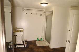 Bathroom with a textured ceiling, vanity, a shower with door, and hardwood / wood-style floors