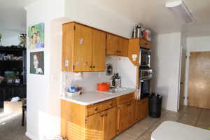 Kitchen featuring light tile patterned floors and appliances with stainless steel finishes