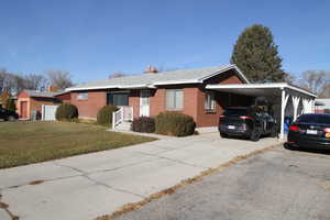 Ranch-style house featuring a carport and a front yard