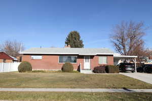 Ranch-style house with a front lawn and a carport