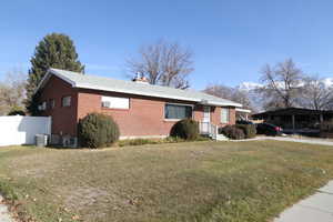 Single story home featuring a mountain view, cooling unit, and a front lawn