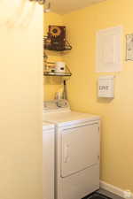 Clothes washing area featuring washing machine and dryer and electric panel