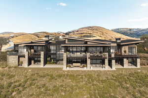 Rear view of property featuring a mountain view and a lawn