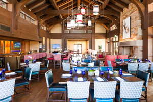 Dining area with beamed ceiling, dark hardwood / wood-style flooring, high vaulted ceiling, and wooden walls