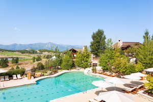 View of swimming pool with a mountain view, a water slide, and a patio