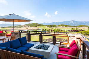 View of patio featuring a mountain view, a balcony, and an outdoor living space with a fire pit