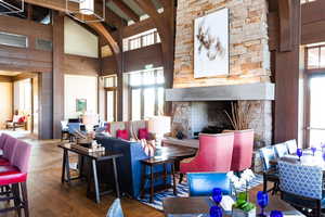 Living room with hardwood / wood-style floors, a fireplace, high vaulted ceiling, and beamed ceiling