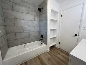 Bathroom with hardwood / wood-style floors, vanity, built in features, and tiled shower / bath