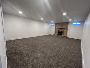 Basement with a fireplace and dark carpet