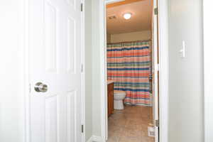 Bathroom featuring walk in shower, vanity, and toilet