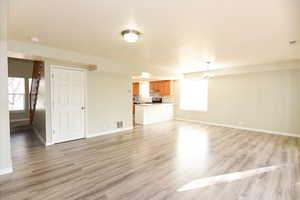 Unfurnished living room with light hardwood / wood-style floors and a chandelier