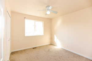 Carpeted empty room with ceiling fan