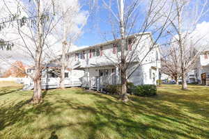 Rear view of property with a yard and a wooden deck