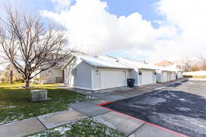 View of home's exterior featuring a garage and a yard