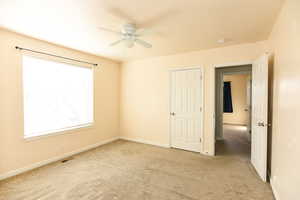 Interior space with light carpet and ceiling fan