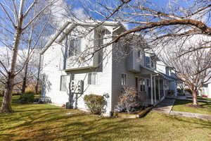 View of side of property featuring a yard and covered porch