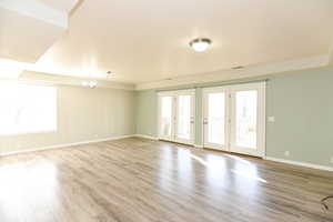 Spare room with an inviting chandelier and light wood-type flooring