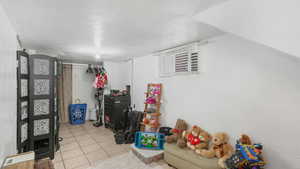 Game room with light tile patterned floors