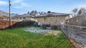 Back of house featuring a mountain view and a lawn