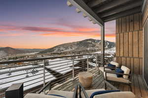 Snow covered back of property with a mountain view