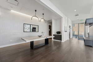 Interior space with a kitchen breakfast bar and dark hardwood / wood-style floors