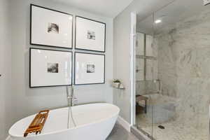 Bathroom featuring tile patterned flooring and shower with separate bathtub