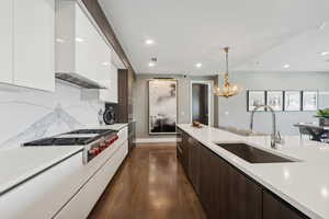 Kitchen featuring dark brown cabinetry, white cabinetry, stainless steel gas cooktop, and sink