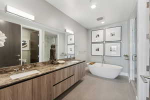 Bathroom featuring separate shower and tub, tile patterned floors, and vanity