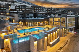 Snow covered pool featuring a mountain view and a patio area