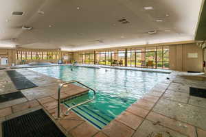 View of pool with an indoor in ground hot tub and a patio area