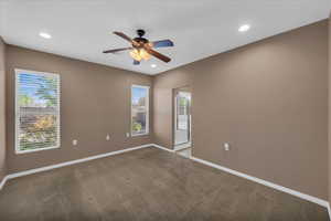 Carpeted empty room featuring ceiling fan